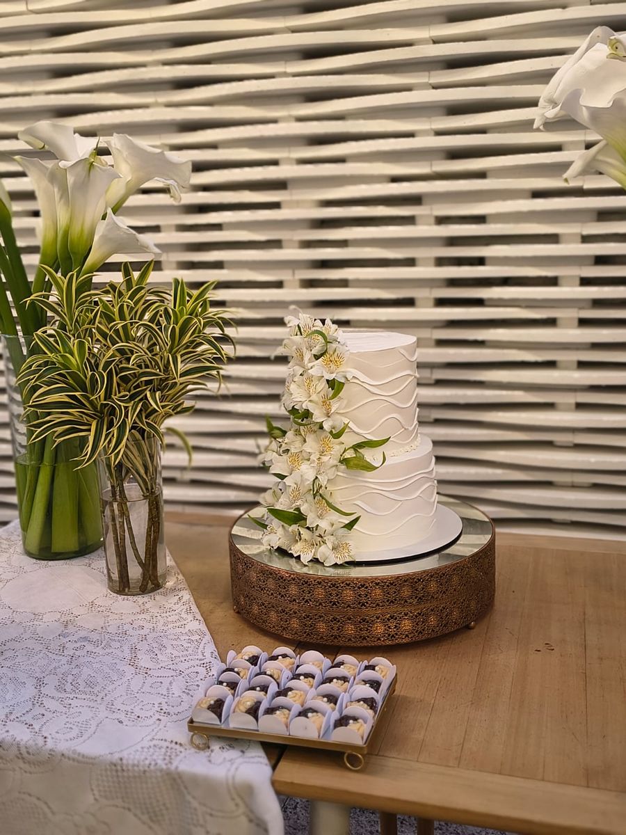 Bolo de casamento de dois andares em chantininho branco com textura em ondas e cascata de flores naturais, feito pela Dulcíssima em Todos os Santos, RJ